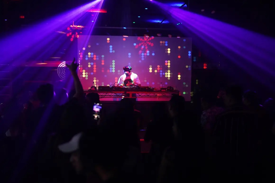 Shredy DJing under lasers to a packed dancefloor